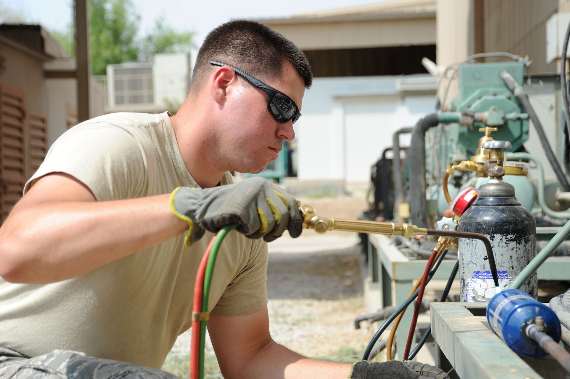 Senior Airman Kyle Cvoliga, 386th Expeditionary Civil Engineer Squadron heating, ventilation, and air conditioning technician, uses a blowtorch to fix a leak on an A/C unit Sep. 2, 2016, at an undisclosed location in Southwest Asia. The 386 ECES HVAC shop is responsible for fixing and maintaining over 725 A/C units across the base. (U.S. Air Force photo/Senior Airman Zachary Kee)