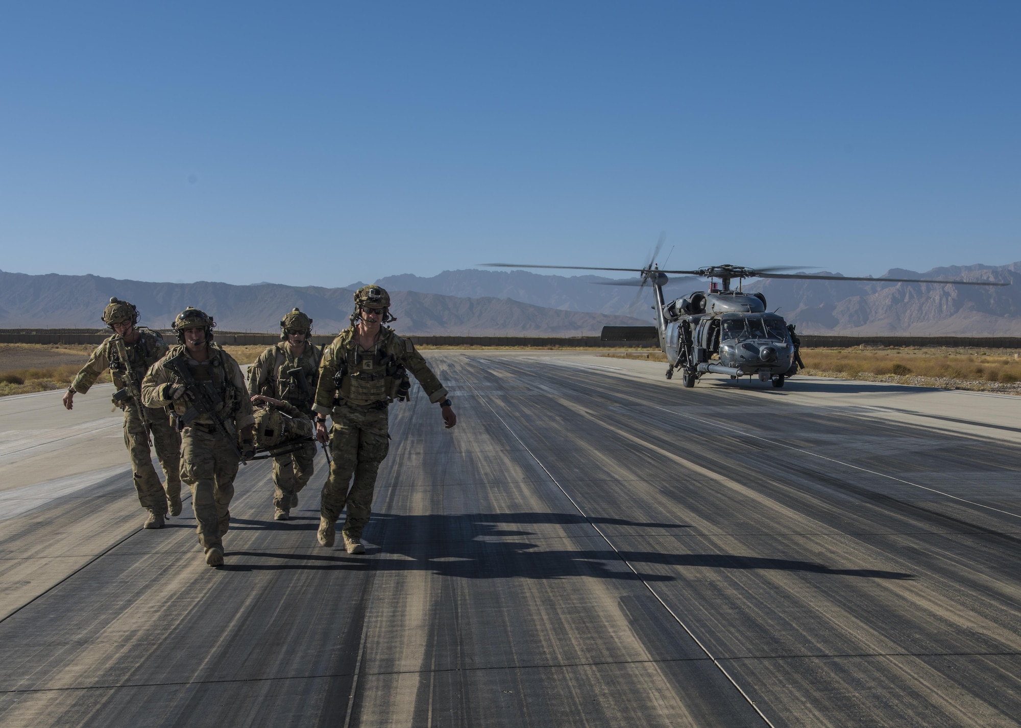 Pararescuemen from the 83rd Expeditionary Rescue Squadron carry a simulated wounded patient during a recovery exercise, Bagram Airfield, Afghanistan, Sept. 03, 2016. Airmen from the 83rd ERQS, 774th Expeditionary Airlift Squadron, and 455th Expeditionary Aeromedical Evacuation Squadron, conducted a first of its kind mission rehearsal. The mission rehearsal integrated the various units to conduct an aerial insertion of an Air Force personnel recovery team. (U.S. Air Force photo by Senior Airman Justyn M. Freeman)