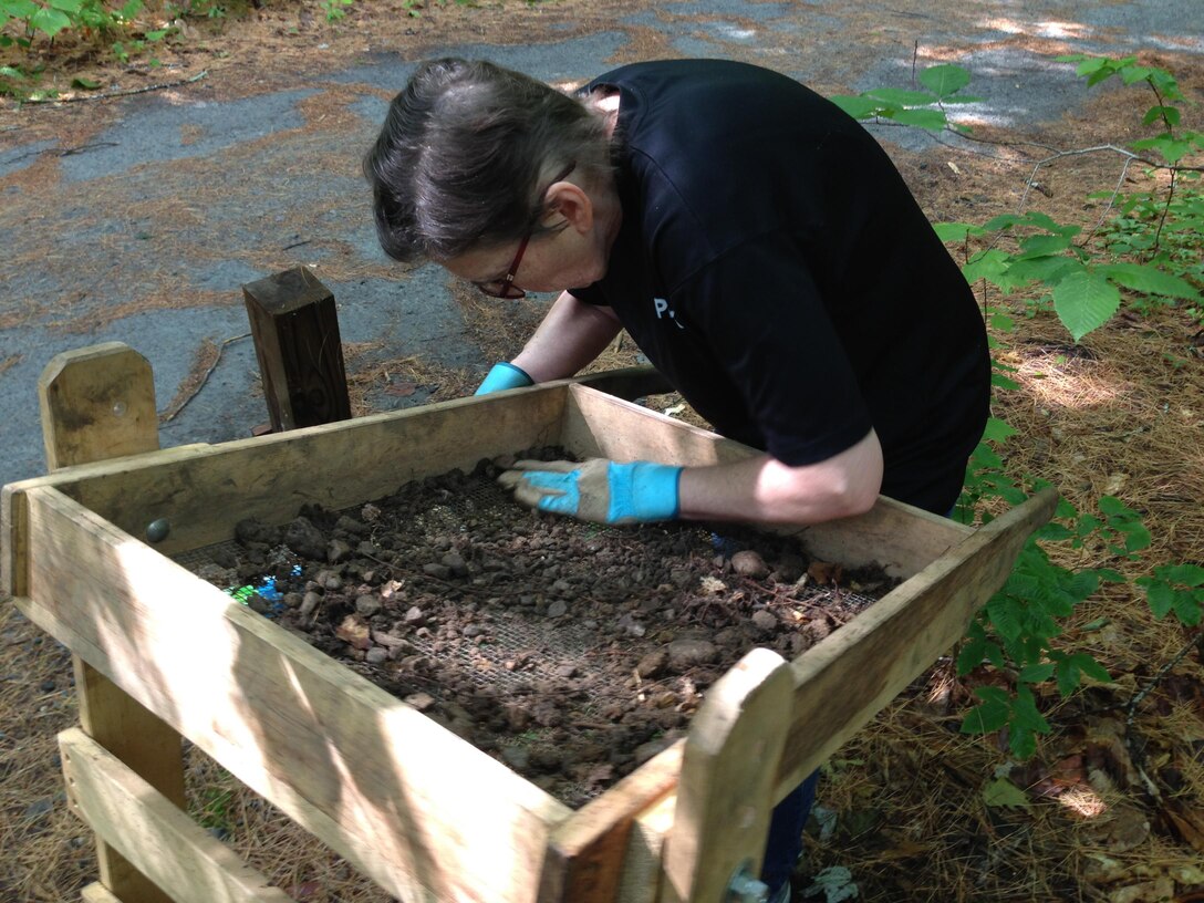 Archeologist Kate Atwood begins the process of sorting through dirt and rocks to look for artifacts.
