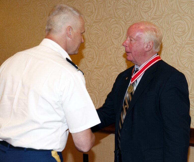 Col. Barron shakes Bill Scully's hand after presenting him with the Bronze De Fleury Medal during his retirement party at the Escadrille Restaraunt in Burlington, Massachusetts on August 11, 2016.