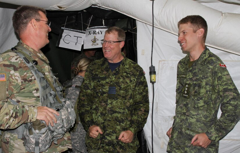 FORT MCCOY, Wis. - Canadian Deputy Surgeon General Scott McLeod (center) jokes with Col. Bryan Brown, 75th Combat Support Hospital executive officer and Canadian Capt. Adam Calabrese, pharmacy officer, Canadian Health Service Atlantic, Aug. 20 during Combat Support Training Exercise 86-16-03 at Fort McCoy, Wis. (U.S. Army Reserve photo by Staff Sgt. Debralee Best)