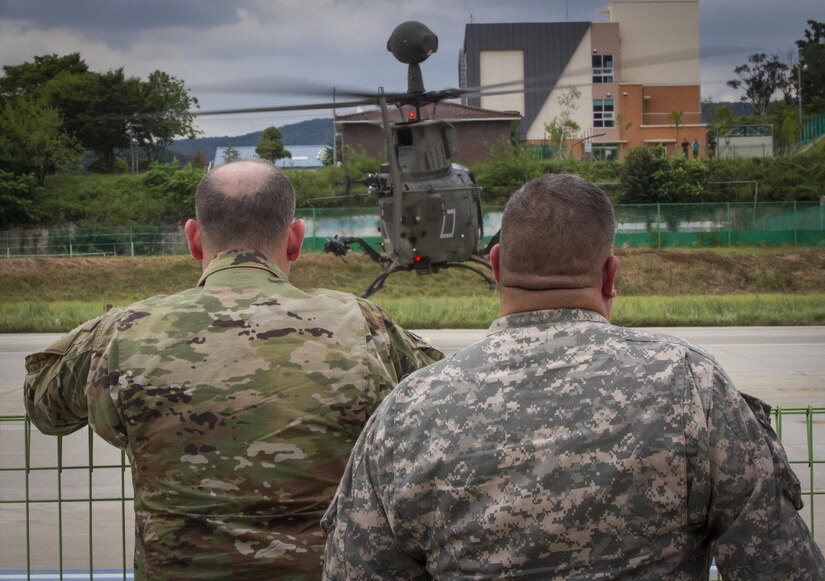 U.S. Army Col. Michael Harvey (left), executive officer to the commanding general of I Corps, and Chief Warrant Officer Jim Israel, I Corps senior warrant officer, watch a OH-58D Kiowa Warrior take off from an airfield in Yongin, South Korea, Aug. 29, 2016. Both men logged thousands of hours flying the OH-58 during their Army careers. The helicopter belonged to the 1st Squadron, 17th Cavalry Regiment, the last squadron of OH-58’s. Once the 1-17th’s deployment is over the Army will retire all of its OH-58’s, replacing them with the farther-reaching Apaches and Blackhawks. (U.S. Army photo by Staff Sgt. Ken Scar)