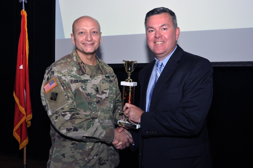 U.S. Army Training and Doctrine Command G-1/4 Assistant Deputy Chief of Staff Hugh Davis receives the “most improved” trophy for his efforts during the six-month Eustis Civilian Fitness Commander’s Cup Challenge from Senior Commander, Maj. Gen. Anthony C. Funkhouser during an awards ceremony at Fort Eustis, Va., Aug. 31, 2016.  (U.S. Army photo by Stephanie Slater)