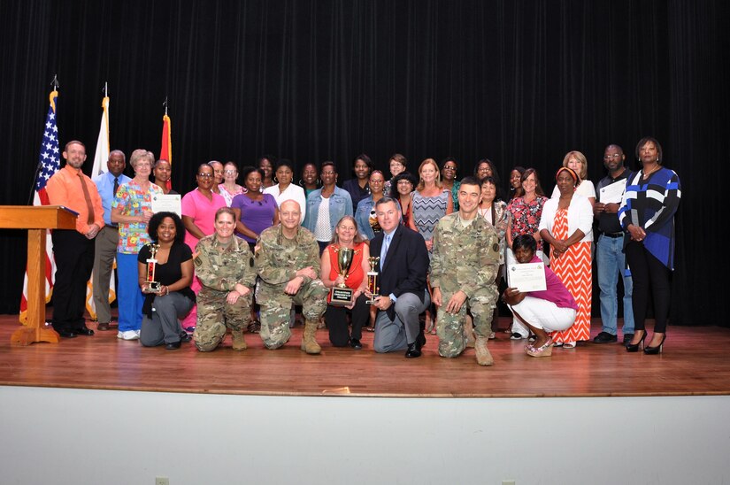 Winners and participants of the Fort Eustis Civilian Fitness Commander’s Cup Challenge pose for a group photo following an awards ceremony at Fort Eustis, Va., Aug. 31, 2016. They are joined by Senior Commander, Maj. Gen. Anthony C. Funkhouser and U.S. Army Training and Doctrine Command G-1/4 Assistant Deputy Chief of Staff Hugh Davis. (U.S. Army photo by Stephanie Slater)