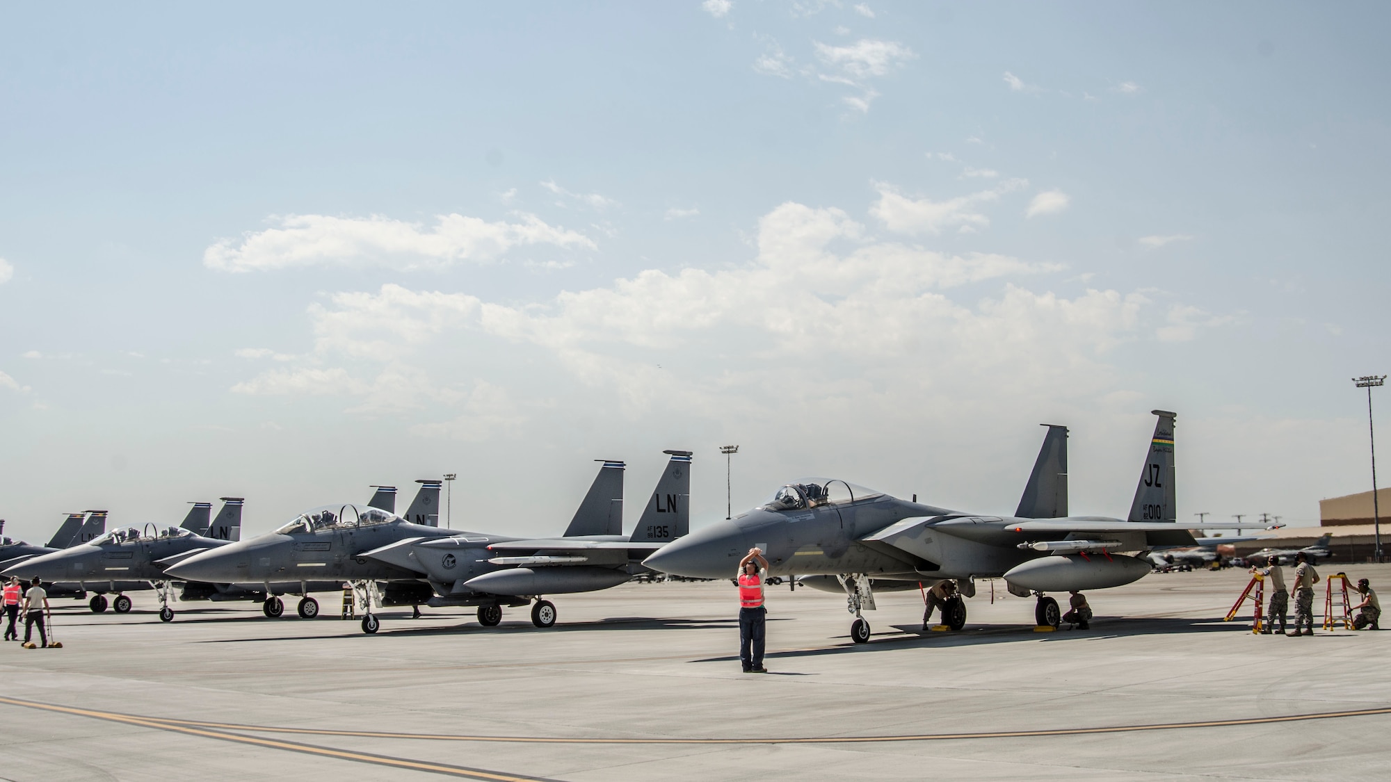 An F-15C Eagle from the 122nd Fighter Squadron, assigned to the 159th Fighter Wing, Louisiana Air National Guard, awaits permission to take off next to four F‐15E Strike Eagles assigned to the 492nd Fighter Squadron, Royal Air Force Lakenheath, England, during a day sortie at Nellis Air Force Base, Nev., Aug. 24, 2016. The main difference between the F-15C and F-15E model is the C model only has one seat and is designed only for air-to-air combat, whereas the F-15E model has a second seat for a weapon systems officer and focuses primarily on dropping munitions on targets. (U. S. Air Force photo by Tech. Sgt. Frank Miller)