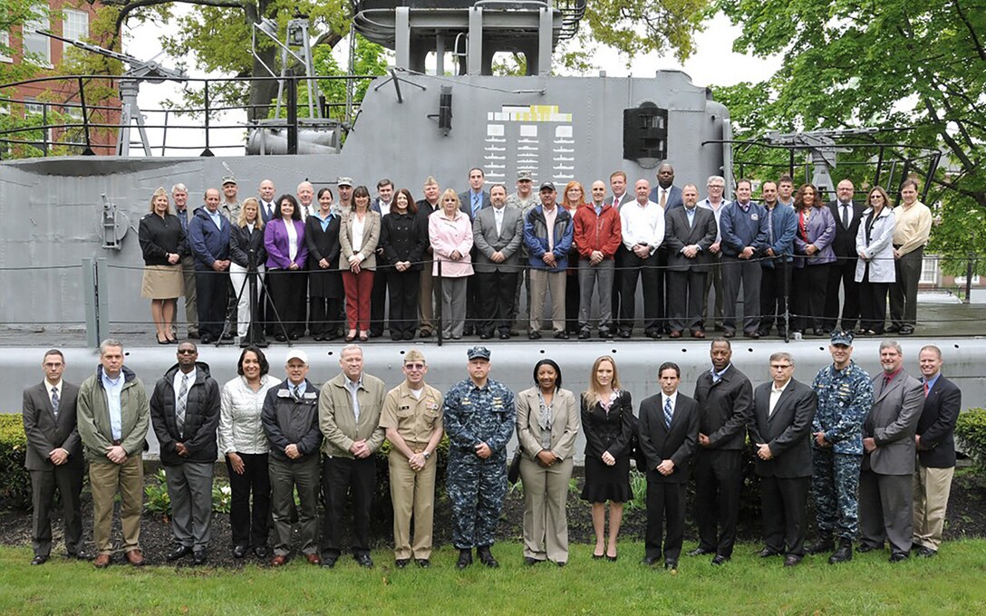 Participants of the DLA Semi-Annual Total Retail Sustainment Review gather at the mast of the USS Sailfish (formerly USS Squalus) at the Portsmouth Naval Shipyard in Maine. 