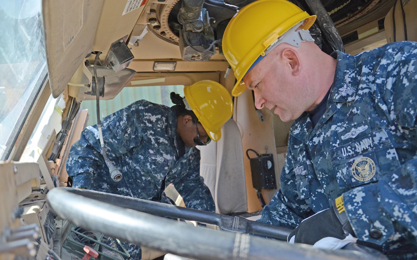 Navy logistics personnel search a Caiman Mine Resistant, Ambush Protected vehicle in Battle Creek, Michigan, for errant ammunition before destroying it in accordance with U.S. demilitarization policies.