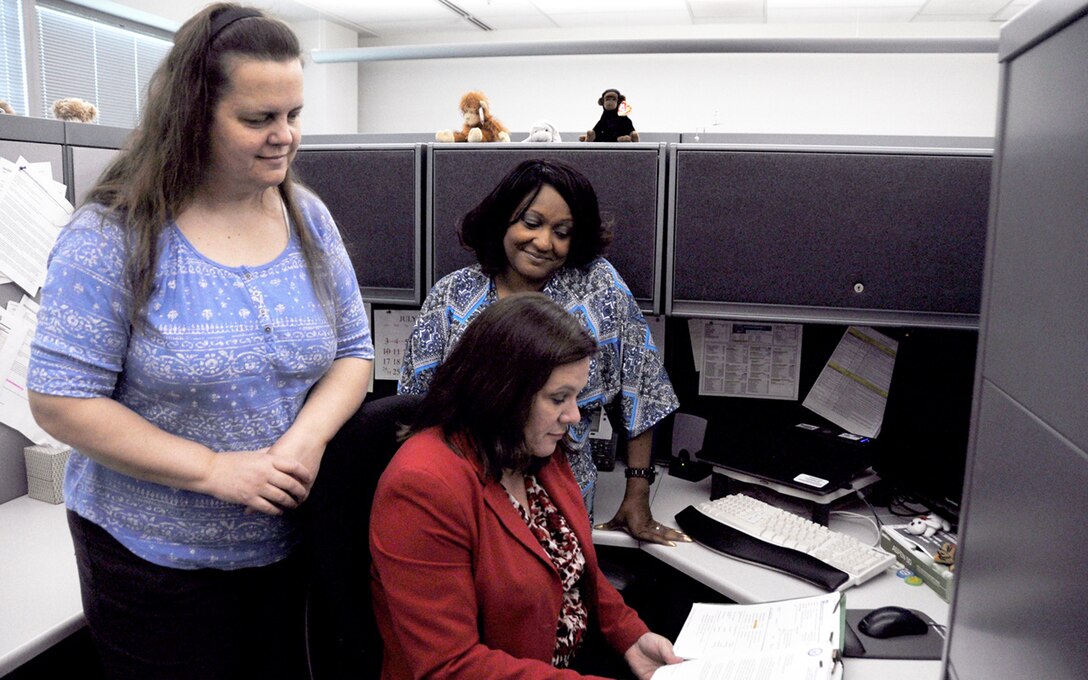 (L-R) Lead Injury Compensation Program Administrators Donna Carr and Patricia Royster discuss a claim with DLA’s Human Resources Services Injury Compensation Office Director Donna Estep.