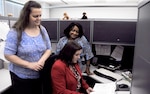 (L-R) Lead Injury Compensation Program Administrators Donna Carr and Patricia Royster discuss a claim with DLA’s Human Resources Services Injury Compensation Office Director Donna Estep.