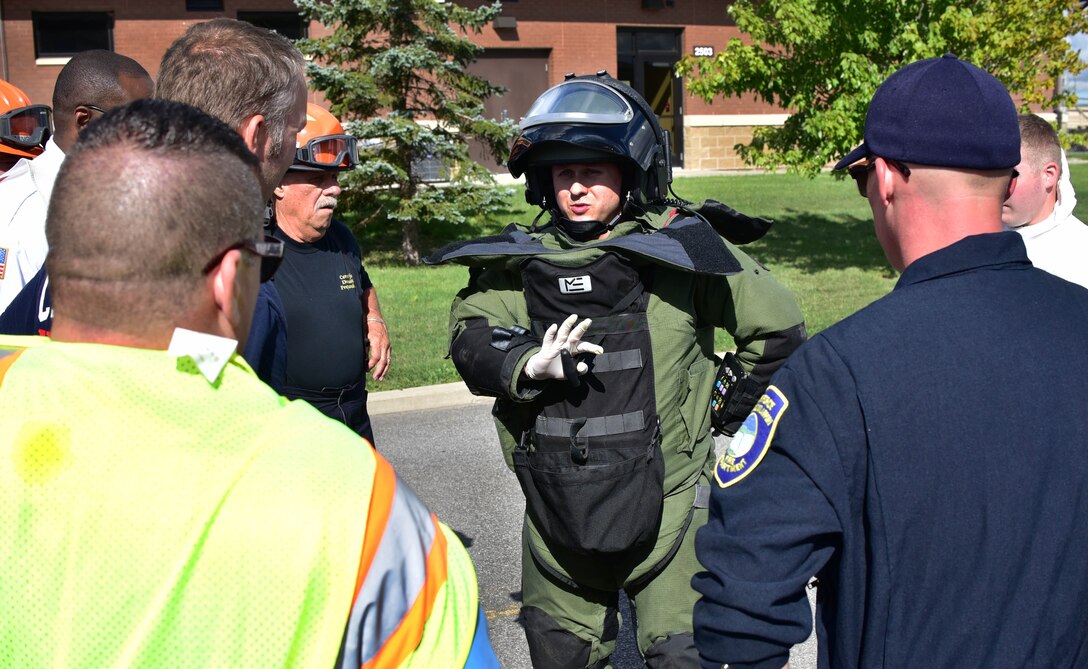 Tech. Sgt. Aaron Clark, EOD team leader, 914th Airlift Wing Civil Engineer Squadron, instructs various base first responder personnel on the removal of an EOD bomb suit at an exercise on Thursday, September 1, 2016. The exercise showcased interoperability of base and local first responder units in a simulated bomb attack. (U.S. Air Force photo by Staff Sgt. Richard Mekkri/released)