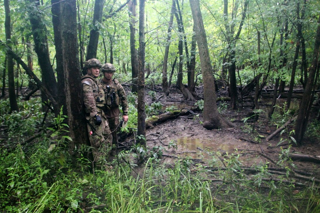 The 932nd Airlift Wing's Explosive Ordnance Disposal team members Tech. Sgt. Blake Witte (left) and Staff Sgt. Kody Bloodworth (holding gear), consider their best way through a swampy area during a practice session.  They worked through a process to meticulously prepare heavy duty string and clips to acquire their possible hazardous "target", and remove a potential explosive hazard, during a training scenario at Scott Air Force Base on August 13, 2016. Airmen of the 932nd Civil Engineering Squadron battled the elements of rain, summer heat, humidity, and thick mud along with various bugs deep in the woods, but they managed their resources and kept squadron camaraderie high. They are part of the 932nd CES, utilized under 22nd Air Force, an Air Force Reserve Command unit. (U.S. Air Force photo by Maj. Stan Paregien)