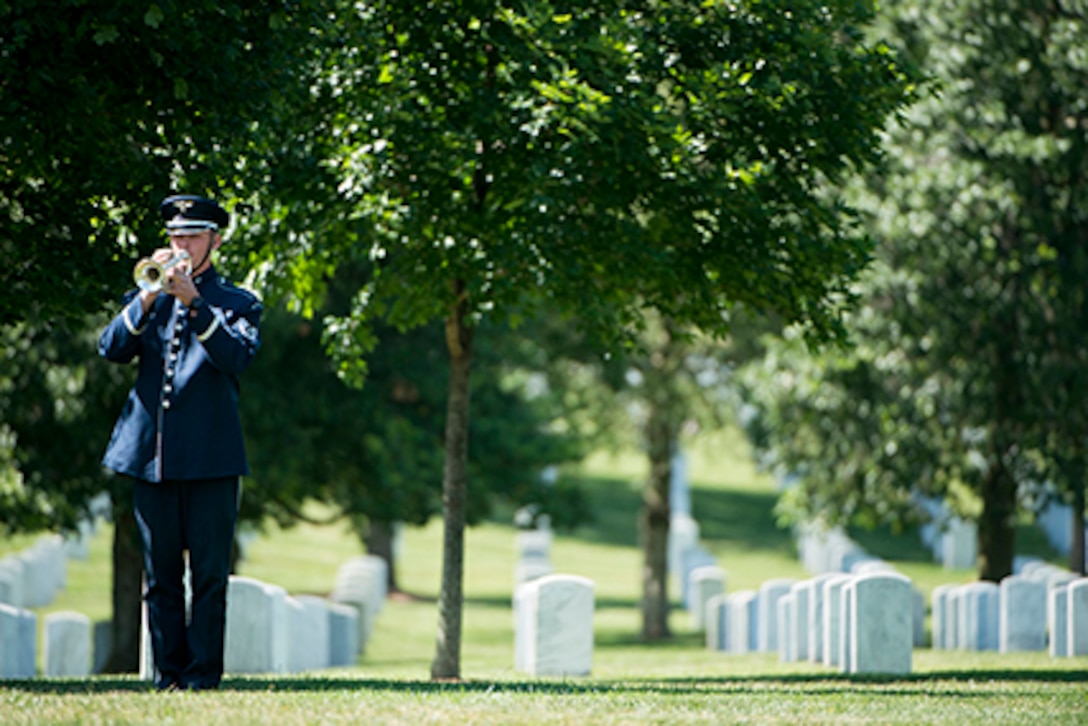A bugler with the U.S. Air Force plays Taps during the graveside service for 2nd. Lt. Malvin Greston "Marvelous Mal" Whitfield in Section 8 of Arlington National Cemetery, June 8, 2016, in Arlington, Va. Whitfield was a five-time Olympic medalist and a Tuskegee Airman. 