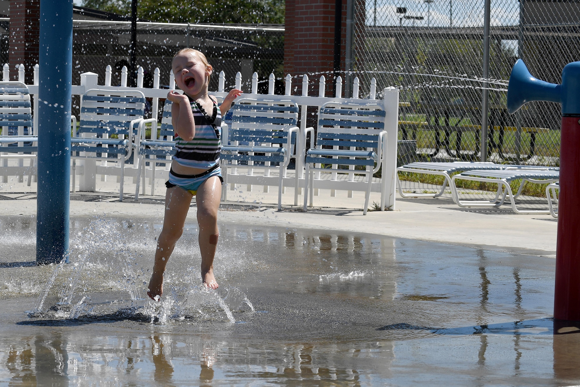 Autumn Hughes runs through the sprinkler section of the outdoor pool during the Labor Day “Splash Party,” Sept. 5, 2016, at Moody Air Force Base, Ga. In addition to the pool and water slide, the outdoor pool features a variety of sprinklers for children to enjoy. (U.S. Air Force photo by Staff Sgt. Brian J. Valencia)