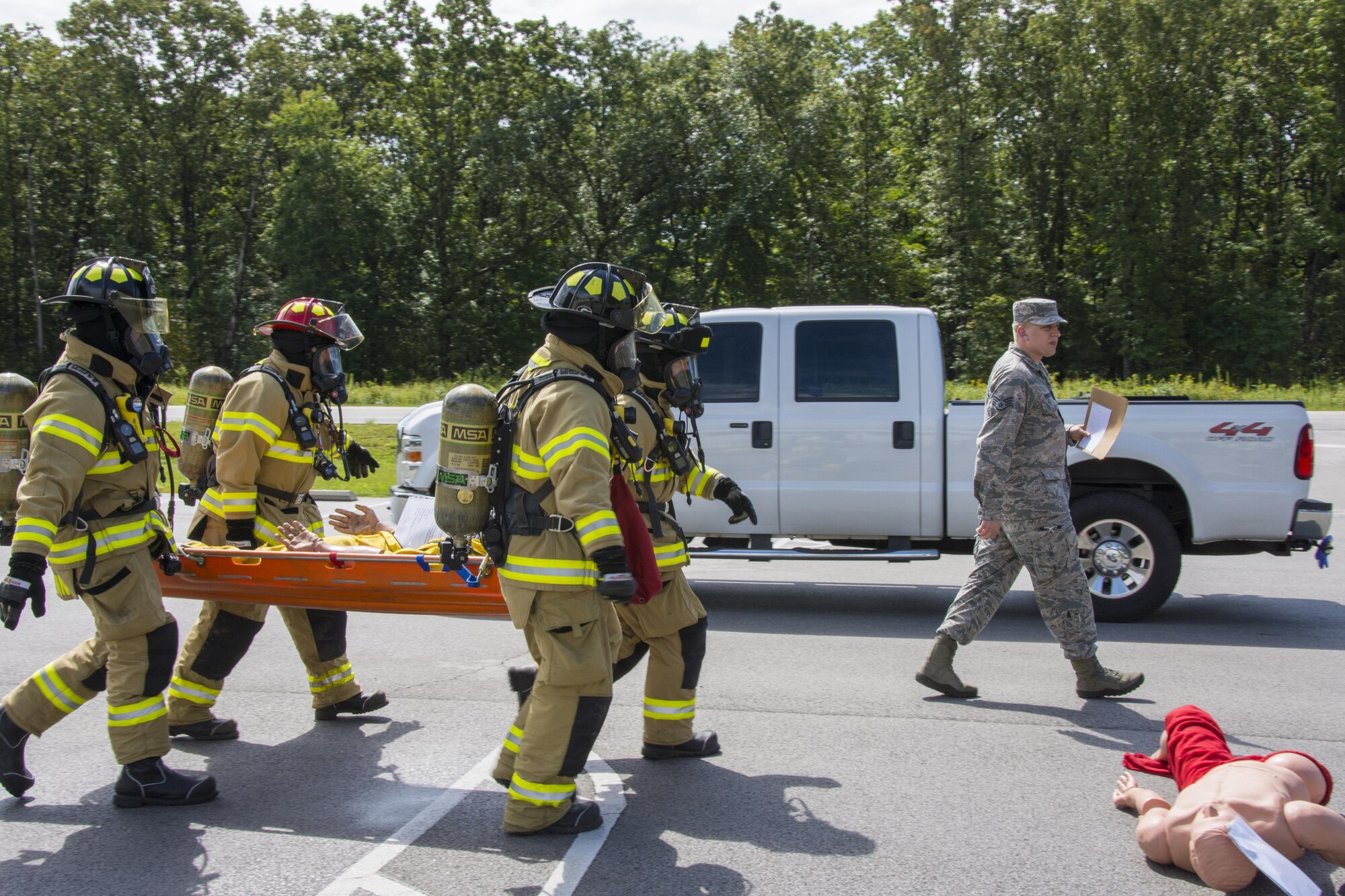 The AEDC Fire-Rescue team transport the training mannequins to emergency personnel for examination.
