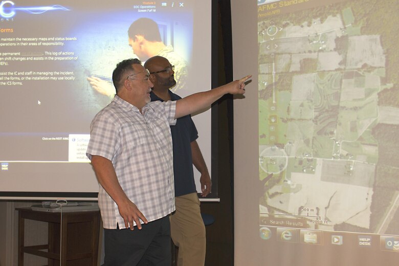 Armando Aguirre, geospatial information specialist and Geospatial Information Office manager at AEDC, reviews Arnold Air Force Base geographical information with AEDC Emergency Management Program manager Lee Smith, using the Arnold AFB GeoBase Viewer. As a GIS and GIO manager, Aguirre manages and provides data about AEDC locations that aid in land surveying, natural and cultural resource management, emergency management, utilities operations, air and space operations, security and other areas. (U.S. Air Force photos/Holly Peterson)