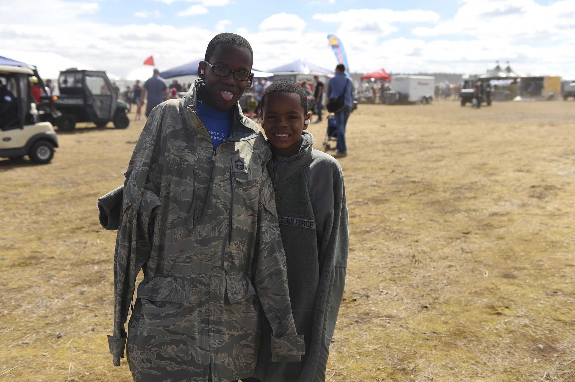 Two brothers walk around during the Joint Base Lewis-McChord Airshow and Warrior Expo Aug. 27, 2016, at JBLM, Wash. The Airshow and Warrior Expo drew crowds from across the state of Washington to the base for the various air show demonstrations. (U.S. Air Force photo/Staff Sgt. Naomi Shipley)