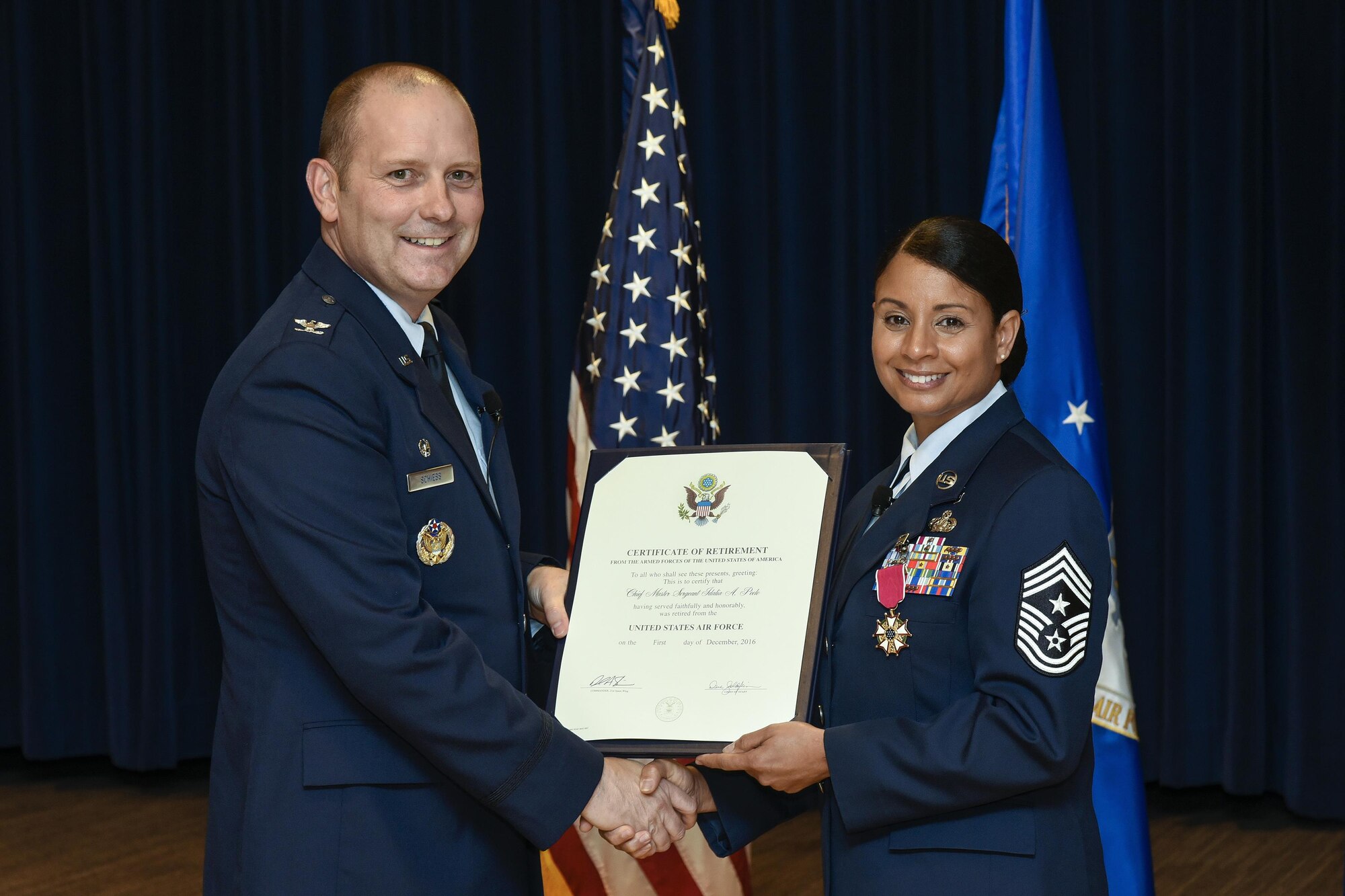 PETERSON AIR FORCE BASE, Colo. – Chief Master Sgt. Idalia Peele, outgoing 21st Space Wing command chief, receives a certificate of retirement during a ceremony at The Club on Peterson Air Force Base, Colo., Aug. 25, 2016. Peele’s military service took her across the world and spanned several different positions throughout more than 29 years in the Air Force. (U.S. Air Force photo by Craig Denton) 