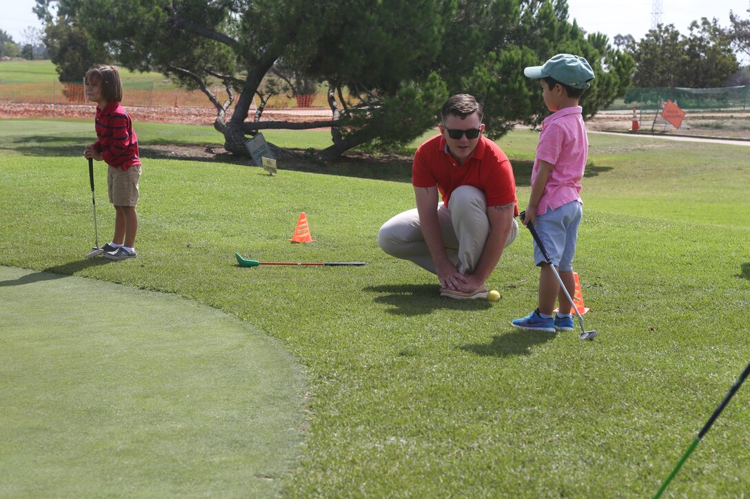 U.S. Marine Sgt. Brandon Rowland, an explosive ordinance technician with 7th Engineer Support Battalion, teaches a child the fundamentals of golf during a clinic at The Last Tee Los Angeles as a part of L.A. Fleet Week in Carson, Calif., Sept. 3, 2016. (U.S. Marine Corps photo by Lance Cpl. Tyler Harrison)