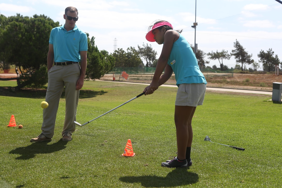 Cpl. Jacob Crafton, a helicopter mechanic with Marine Light Attack Helicopter Squadron 369, helps a young golfer work on her swing during a clinic, hosted by The First Tee Los Angeles, as a part of L.A. Fleet Week in Carson, Calif., Sept. 3, 2016.  Fleet week provides members of the sea services with the opportunity to meet the people of L.A. and surrounding communities and thank them for their support. (U.S. Marine Corps photo by Lance Cpl. Tyler Harrison)