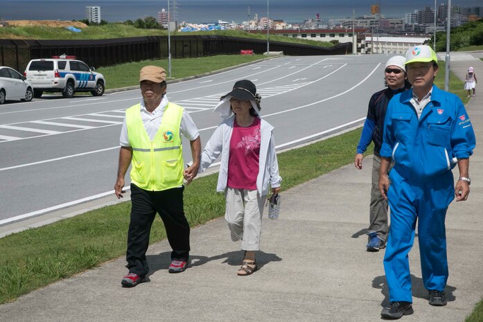 Okinawa residents walk toward a safety checkpoint during the tsunami evacuation drill Sept. 4 on Camp Foster, Okinawa, Japan. The drill was arranged to familiarize Okinawa residents with the evacuation route. In the event of a tsunami, Okinawa residents would follow the evacuation route through Camp Foster to higher ground. (U.S. Marine Corps Photo by Cpl. Brittany A. James/ Released)