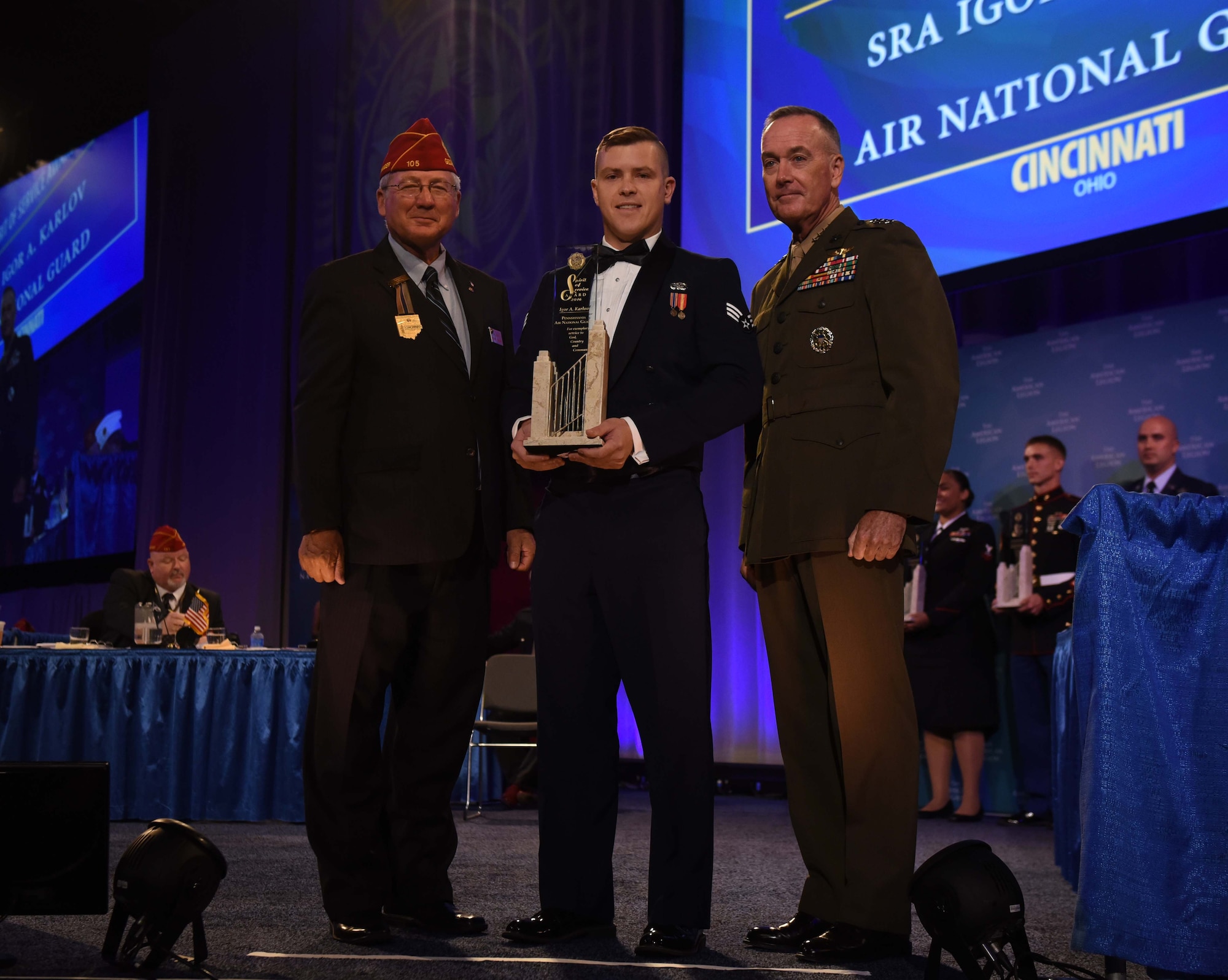 Senior Airman Igor Karlov, a 111th Logistics Readiness Squadron supply technician, receives The American Legion Spirit of Service Award from The American Legion National Commander Dale Barnett and Chairman of the Joint Chiefs of Staff Gen. Joseph F. Dunford during The American Legion’s 98th National Convention at the Duke Energy Convention Center, Cincinnati, Ohio, Aug. 30, 2016. Karlov, a Pa. Air National Guard member, was the first-ever Guardsman to receive The American Legion Spirit of Service Award in the 17 years it has been awarded to military members. (U.S. Air National Guard photo by Tech. Sgt. Andria Allmond)