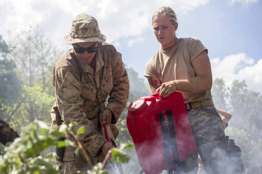 Marine Lance Cpl. Maxwell Martin, left, and Army 2nd Lt. Shelby Blad extinguish a signal fire during Exercise Kowari at Daly River Region, Northern Territory, Australia, Sept. 3, 2016. The exercise enhances the friendship among United States, Australia and China through trilateral cooperation in the Indo-Asia-Pacific region. Marine Corps photo by Lance Cpl. Osvaldo L. Ortega III