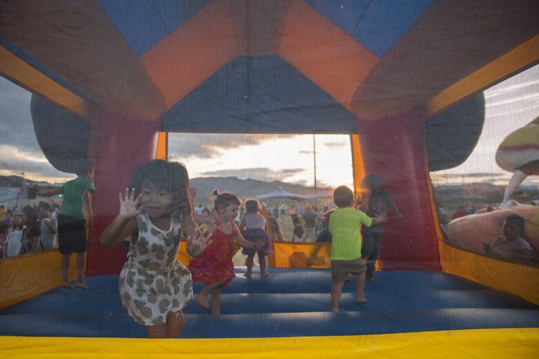Local Japanese and Marine Corps Air Station Iwakuni resident children play in a bounce house during the Summer Music Festival hosted by Marine Corps Community Services at MCAS Iwakuni, Japan, Aug. 27, 2016. Service members, families and local Japanese residents were invited to enjoy a night of free music, food and fun at Penny Lake to come together and celebrate the end of summer. (U.S. Marine Corps photo by Lance Cpl. Donato Maffin)