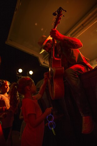 Scott Brown, the lead singer of the Scooter Brown Band and former Marine combat veteran, lets a Marine Corps Air Station Iwakuni child strum his guitar during their performance at the Summer Music Festival hosted by Marine Corps Community Services at MCAS Iwakuni, Japan, Aug. 27, 2016. This was the band’s first visit to MCAS Iwakuni. They performed as the headline during the festival, which also included local bands from Iwakuni and Hiroshima. The Summer Music Festival was put together for service members, residents and Japanese locals to enjoy the end of the summer with free music, food and fun. (U.S. Marine Corps photo by Lance Cpl. Donato Maffin)