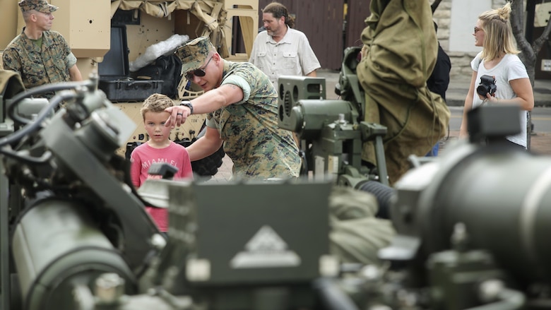 Staff Sgt. Michael Rickard, center, a section chief with 3rd Battalion, 14th Marine Regiment based out of Bristol, Penn., shows Mason McPherson an M777A2 Howitzer during a static display in Nashville, Tenn., Sept. 6. More than 800 Marines are participating in Marine Week Nashville to give the citizens of the greater Nashville area the opportunity to meet the individual Marines and celebrate community, country and Corps.