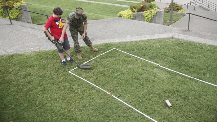 Capt. Jeremy Walker, center, a project officer with Marine Corps Systems Command based out of Quantico, Va., shows David Owen, left, how to use a compact metal detector during a static display in Nashville, Tenn., Sept. 6, 2016. Marine Week Nashville is an opportunity for the people of the greater Nashville area to meet Marines and learn about Corps’ history, traditions and value to the nation.