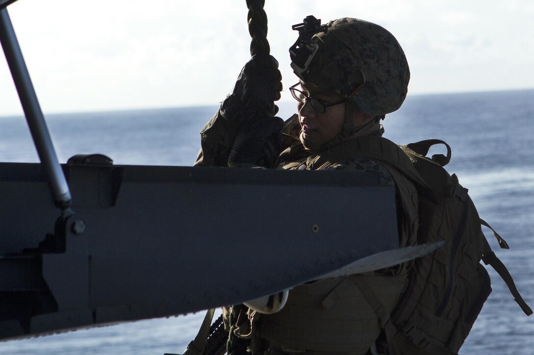 Marine Corps Lance Cpl. David A. Chang fast-ropes from the exit ramp of an MV-22B Osprey tiltrotor aircraft during training aboard the amphibious assault ship USS Bonhomme Richard at sea, Sept. 3, 2016. Chang is a rifleman assigned to Echo Company, Battalion Landing Team, 2nd Battalion, 4th Marines. Marine Corps photo by Staff Sgt. T.T. Parish