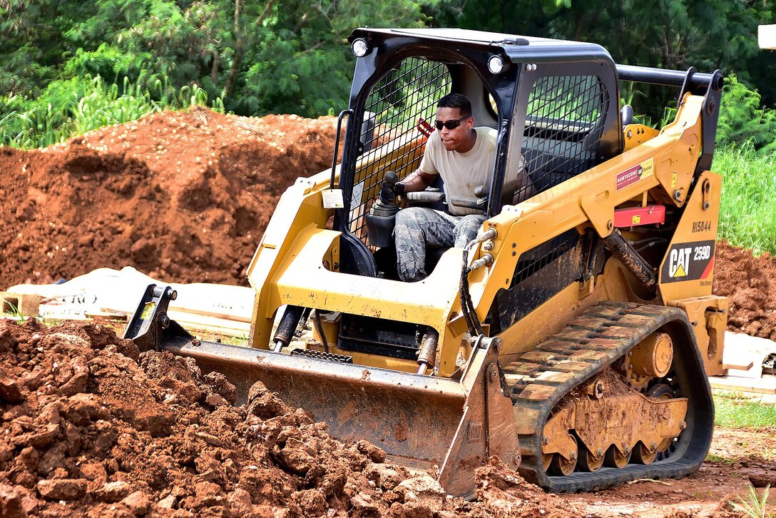 Air Force Staff Sgt. Bruno Ramos operates a compact track loader to move a pile of dirt to create a drainage trench during an Innovative Readiness Training project in Inarajan, Guam, Sept. 1, 2016. Ramos is assigned to the Rhode Island Air National Guard’s 143d Civil Engineering Squadron. Air National Guard photo by Master Sgt. John V. McDonald