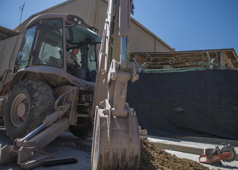 Senior Airman Jacob Nevills, 455th Expeditionary Civil Engineer Squadron pavements and equipment technician, operates a backhoe to remove dirt from a ditch, Bagram Airfield, Afghanistan, Sept. 7, 2016. The engineers, otherwise known as “Dirt Boys”, worked to construct a new drainage system at the passenger’s terminal. (U.S. Air Force photo by Senior Airman Justyn M. Freeman)