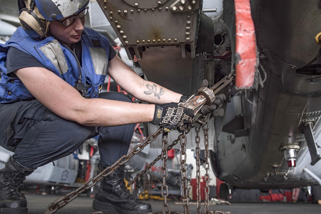Navy Seaman Breanna O'Kelly ties down an MH-60S Seahawk helicopter in the hangar bay of the aircraft carrier USS Dwight D. Eisenhower in the Persian Gulf, Sept. 4, 2016. The Eisenhower is providing maritime security and theater security cooperation efforts in the U.S. 5th Fleet area of operations to support Operation Inherent Resolve. Navy photo by Seaman Joshua Murray
