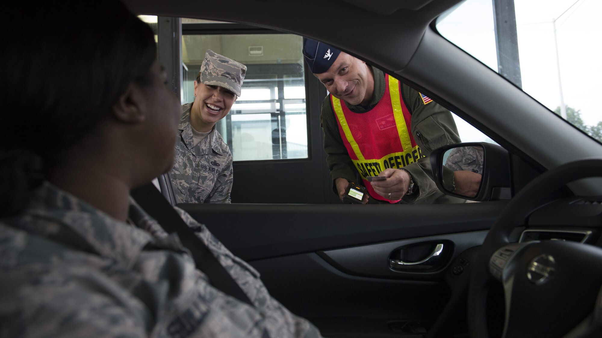 Col. Ethan Griffin, 436th Airlift Wing commander, and Chief Master Sgt. Sarah Sparks, 436th AW command chief, offer safety tips to Airmen and civilians entering Dover Air Force Base for the Labor Day weekend Sept. 1, 2016, at Dover AFB, Del. Griffin and Sparks checked IDs, along with various other members of Team Dover leadership. (U.S. Air Force photo by Senior Airman Zachary Cacicia)