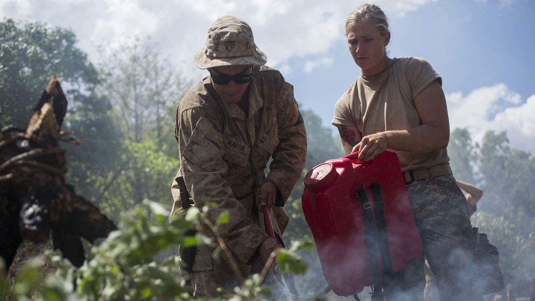U.S. Marine Lance Cpl. Maxwell Martin and U.S. Army soldier 2nd Lt. Shelby Blad extinguish a signal fire during Exercise Kowari at Daly River Region, Northern Territory, Australia, Sep. 3, 2016. The purpose of Exercise Kowari is to enhance the United States, Australia, and China’s friendship and trust, through trilateral cooperation in the Indo-Asia-Pacific region.