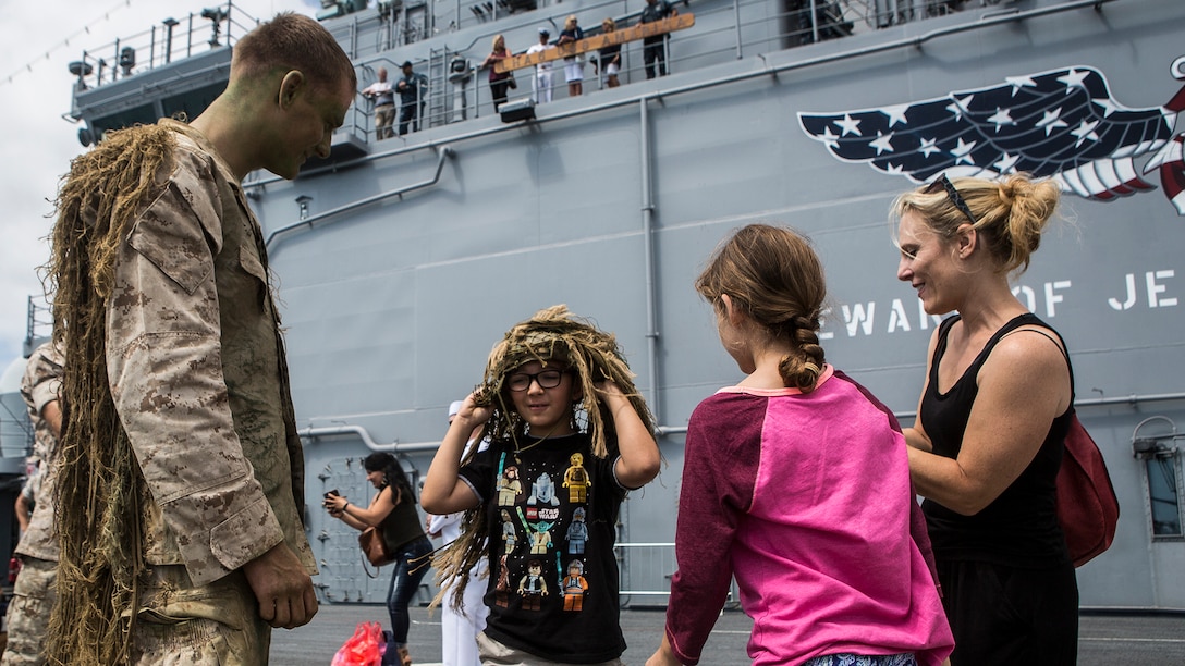 U.S. Marine Cpl. Cory Mersino, a rifleman with Scout Sniper Platoon, 3rd Battalion, 5th Marine Regiment, teaches children about his ghillie suit, during a demonstration at Los Angeles Fleet Week in San Pedro, Calif., Sept. 4, 2016. L.A. Fleet Week is an event designed to showcase the capabilities of the Navy-Marine Corps team to L.A. residents, and an opportunity for members of the sea services to meet and thank the community for its support.