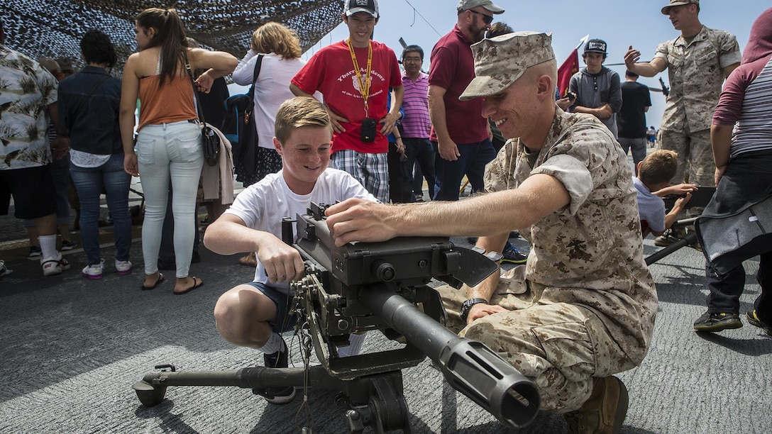 U.S. Marine Sgt. Jesse Haney, an antitank missileman with 3rd Battalion, 5th Marine Regiment, teaches children of the community about the MK-19 Grenade Launcher, during a static display demonstration at Los Angeles Fleet Week in San Pedro, Calif., Sept. 4, 2016. L.A. Fleet Week is an event designed to showcase the capabilities of the Navy-Marine Corps team to L.A. residents, and an opportunity for members of the sea services to meet and thank the community for its support.