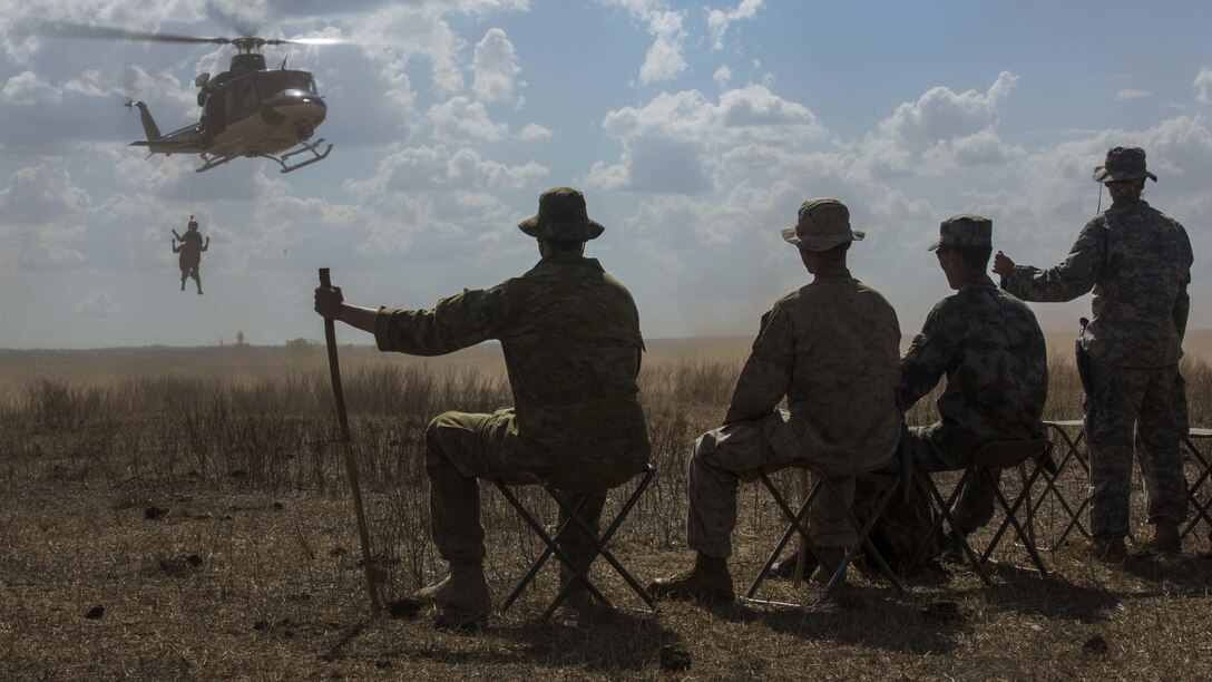 A U.S. Marine and Army soldier, Australian Army soldier, and a People’s Liberation Army soldier watch a winching exercise with aero paramedics during Exercise Kowari at Daly River Region, Northern Territory, Australia, Sept. 3, 2016. The purpose of Exercise Kowari is to enhance the United States, Australia, and China’s friendship and trust, through trilateral cooperation in the Indo-Asia-Pacific region.