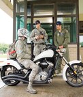 Staff Sgt. Daniel Reshef, 436th Security Forces Squadron unit scheduler, center, and Lt. Col. Ryan Orfe, 3d Airlift Squadron director of operations, right, greet a motorcycle rider as he enters the base Sept. 1, 2016, at the north gate on Dover Air Force Base, Del. As part of the 436th and 512th Airlift Wings Labor Day safety send off, senior leadership and the 436th AW safety office personnel reminded drivers and passengers to be safe over the Air Mobility Command's family day and Labor Day holiday weekend. (U.S. Air Force photo by Roland Balik)
