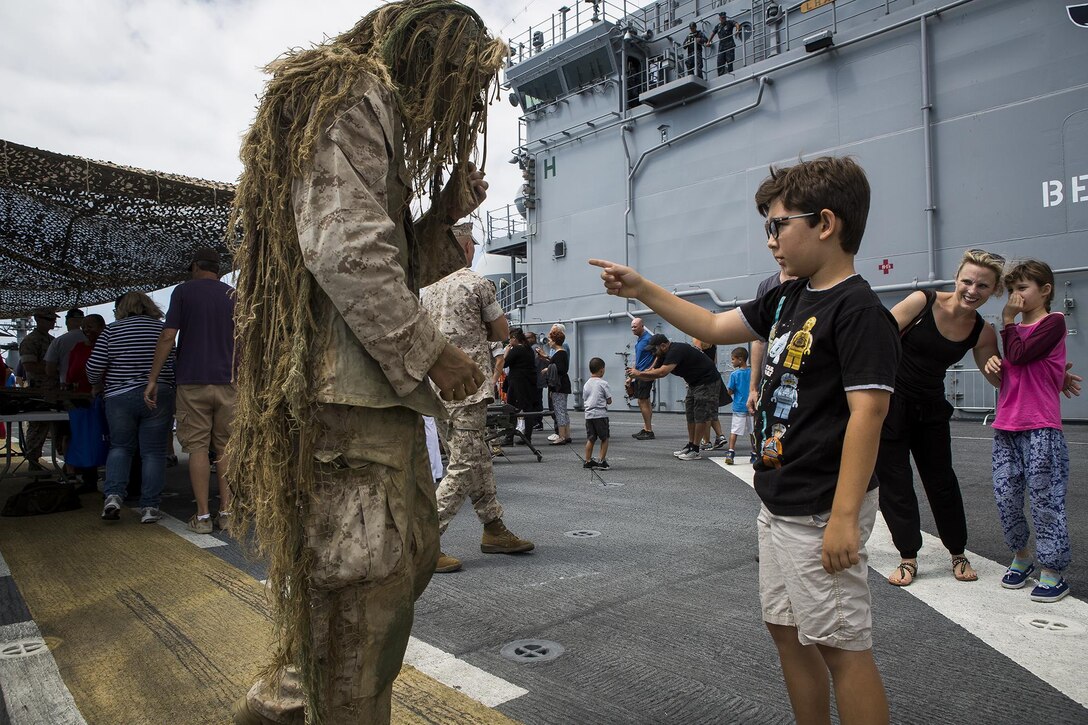 U.S. Marine Cpl. Cory Mersino, a rifleman with Scout Sniper Platoon, 3rd Battalion, 5th Marine Regiment, teaches a child about his ghillie suit, during a demonstration at Los Angeles Fleet Week in San Pedro, Calif., Sept. 4, 2016. L.A. Fleet Week is an event designed to showcase the capabilities of the Navy-Marine Corps team to L.A. residents, and an opportunity for members of the sea services to meet and thank the community for its support. (U.S. Marine Corps photo by Sgt. Rick Hurtado)