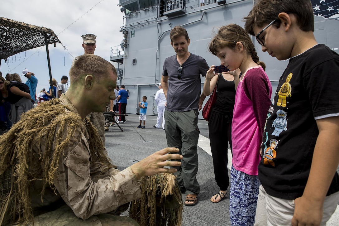 U.S. Marine Cpl. Cory Mersino, a rifleman with Scout Sniper Platoon, 3rd Battalion, 5th Marine Regiment, teaches children about his ghillie suit, during a demonstration as part of Los Angeles Fleet Week in San Pedro, Calif., Sept. 4, 2016. L.A. Fleet Week is an event designed to showcase the capabilities of the Navy-Marine Corps team to L.A. residents, and an opportunity for members of the sea services to meet and thank the community for its support. (U.S. Marine Corps photo by Sgt. Rick Hurtado)