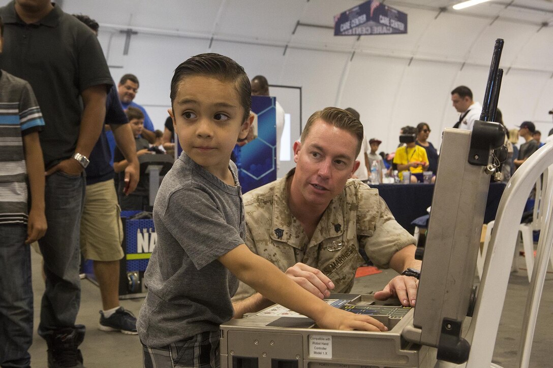 U.S. Marine Sgt. Craig Matz, an explosive ordnance disposal technician with 1st EOD Company, 7th Engineer Support Battalion, shows a Los Angeles child how to operate an iRobot 510 Packbot during a demonstration at Los Angeles Fleet Week in San Pedro, Calif., Sept. 4, 2016. L.A. Fleet Week is an event designed to showcase the capabilities of the Navy-Marine Corps team to L.A. residents, and an opportunity for members of the sea services to meet and thank the community for its support. (U.S. Marine Corps photo by Sgt. Rick Hurtado)