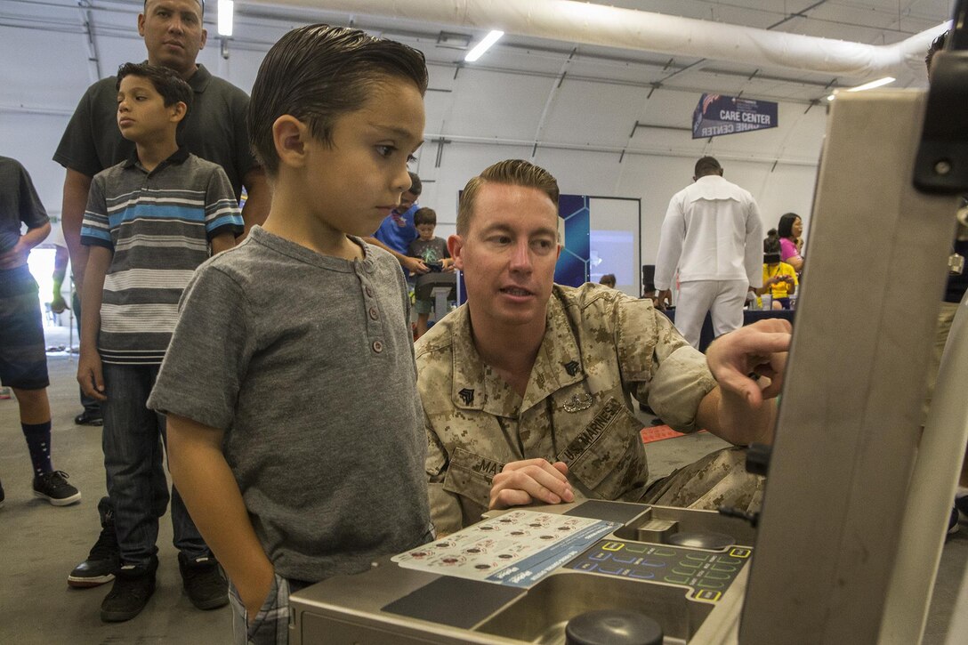 U.S. Marine Sgt. Craig Matz, an explosive ordnance disposal technician with 1st EOD Company, 7th Engineer Support Battalion, shows a Los Angeles boy how to operate an iRobot 510 Packbot during a demonstration as part of Los Angeles Fleet Week in San Pedro, Calif., Sept. 4, 2016. L.A. Fleet Week is an event designed to showcase the capabilities of the Navy-Marine Corps team to L.A. residents, and an opportunity for members of the sea services to meet and thank the community for its support. (U.S. Marine Corps photo by Sgt. Rick Hurtado)