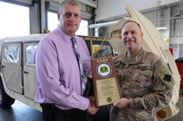 David Graham, left, a heavy mobile equipment repair supervisor for Area Maintenance Support Activity (AMSA) 56, holds the Army Chief of Staff Supply Excellence Award after Maj. Gen. Patrick Reinert, commanding general of 88th Regional Support Command, presented him the award at the Whitehall, Ohio, shop, Aug. 29.