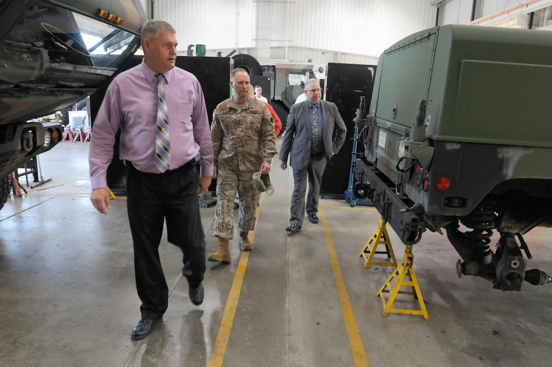 David Graham, left, a heavy mobile equipment repair supervisor for Area Maintenance Support Activity (AMSA) 56, shows Maj. Gen. Patrick Reinert, commanding general of 88th Regional Support Command, and David Fyfe, director of logistics, 88th RSC, around the shop floor after an awards presentation, Aug. 29. The Army Chief of Staff Supply Excellence Award was presented to AMSA 56 for it superior performance during 2015 – a year in which it completed more than 2,600 job orders for more than 90 separate units.