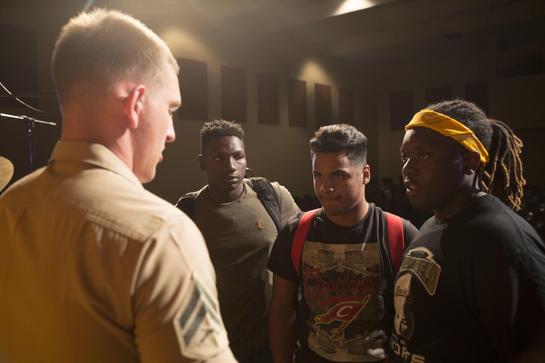 A Marine with the San Diego Marine Band's Rock Band engages with Springfield High School students after a performance as part of Marine Week Nashville, in Springfield, Tenn., Sept. 6, 2016. The concert was held to provide Marines with an opportunity to speak with eligible prospects, key influencers and educators, and promote the Music Enlistment Option Program. Marine Week, an annual event held in a different city each year, is a celebration of Community, Country and Corps that allows the public to learn about the Corps through hands-on static displays, live demonstrations, time-honored Marine Corps traditions, musical performances and more.