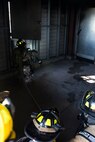 A 375th Civil Engineer Squadron firefighter checks a window during a training scenario at Scott Air Force Base, Ill., Aug. 31, 2016. The scenario was part of an instructor training course and was specifically designed to test an instructor’s ability to work with students in fire conditions to include physical positioning, maneuvering in low visibility, observations of difficulties students are having and unsafe behavior. (U.S. Air Force photo/Tech. Sgt. Jonathan Fowler)