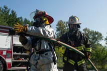 Two firefighters test the spray from a hose during a training class at Scott Air Force Base, Ill., Aug. 31, 2016. The three-day training program explored the most recent National Fire Protection Association standards and applied principles of the standards to the student’s ability to instruct live fire training in a safe environment. The two firefighters were with the 375th Civil Engineer Squadron (left) from Scott AFB and the 19th CES (right) from Little Rock AFB, Arkansas. (U.S. Air Force photo/Tech. Sgt. Jonathan Fowler)