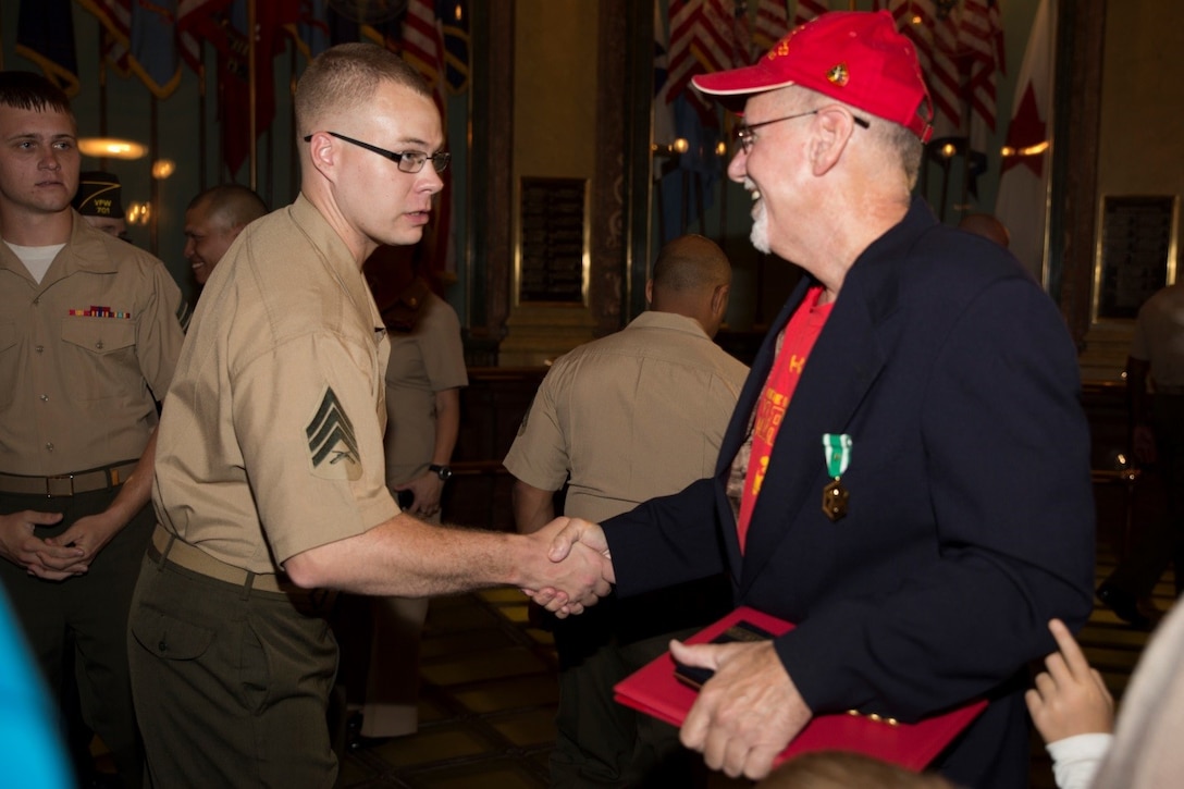 Marines with Company C, 1st Battalion, 24th Marines, 25th Marine Regiment, congratulate Daniel S. Baldwin, a Marine veteran who served in Vietnam, after the award ceremony where he was presented the Navy Commendation Medal with a bronze “V” for valor at the State Capitol building Sept. 2, 2016. The Marines of Co. C had the opportunity to hear Baldwin share his story and the importance of what “Once a Marine, Always a Marine” means to him. (U.S. Marine Corps photo by Cpl. Melissa Martens/ Released)    
